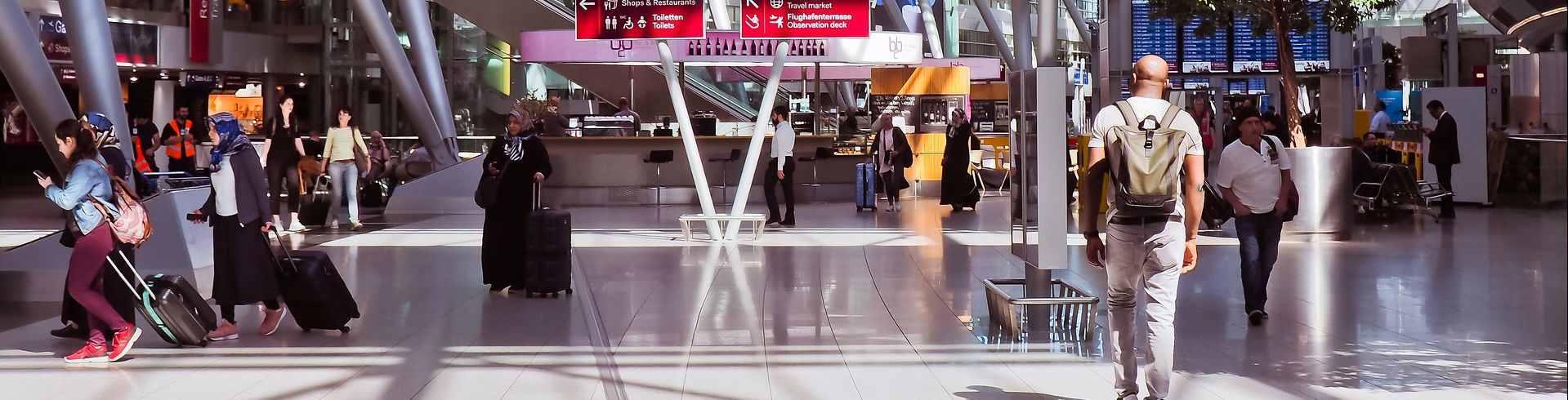 Menschen mit Gepäck auf einem deutschen Flughafen